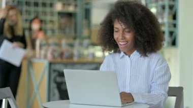 Cafe 'de laptopta video görüşmesi yapan Afrikalı profesyonel bir iş kadını. 