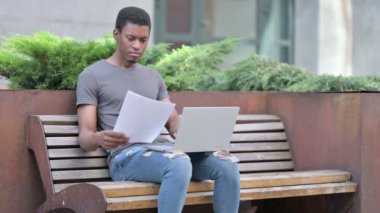 Genç Afrikalı Kayıp Dosyaları ve Laptop üzerinde çalışıyor