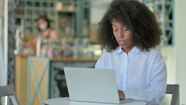 Gestresste afrikanische Geschäftsfrau mit Laptop hat Kopfschmerzen im Café — Stockvideo