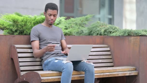 El éxito del pago en línea en el ordenador portátil por el hombre joven africano — Vídeo de stock