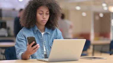 İş yerinde Akıllı Telefon ve Laptop kullanan Afrikalı Kadın 