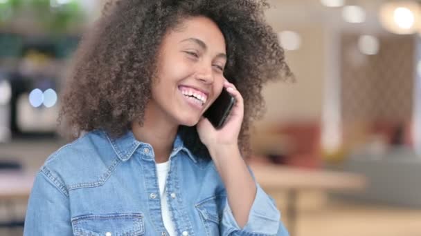 Счастливая африканская женщина разговаривает по телефону — стоковое видео