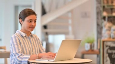 Laptoplu genç Hintli Kadın Kafedeki Kameraya Gülümsüyor 