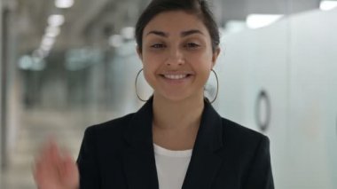 Kameraya el sallayan neşeli Hintli genç iş kadınının portresi 