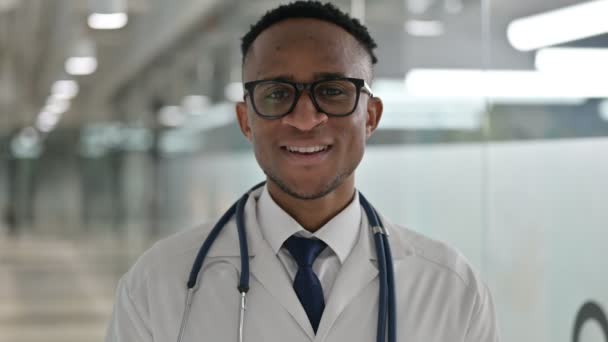 Portret van vrolijke jonge Afrikaanse mannelijke arts glimlachend naar de camera — Stockvideo