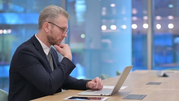 Pensive jeune homme d'affaires Penser et travailler sur ordinateur portable dans le bureau — Video