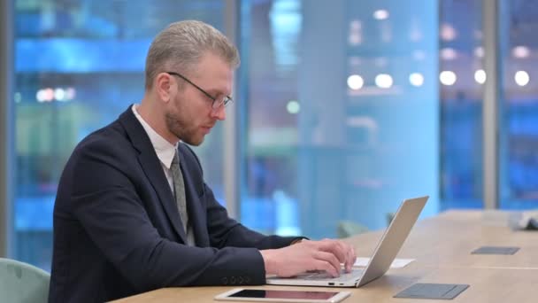 Jeune homme d'affaires travailleur avec ordinateur portable ayant mal à la tête au bureau — Video