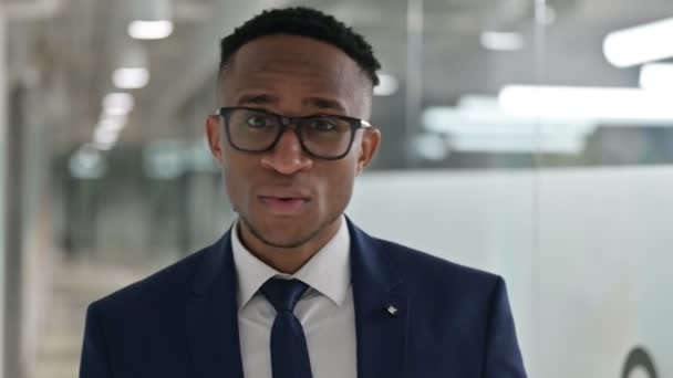 A boldog fiatal afrikai üzletember portréja ujjal mutogatva — Stock videók