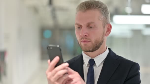 Portrait de joyeux jeune homme d'affaires parlant sur Smartphone — Video
