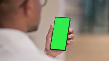 Krom Ekran ile Akıllı Telefon kullanan Erkek Afrikalı Doktorun Arka Görünümü 