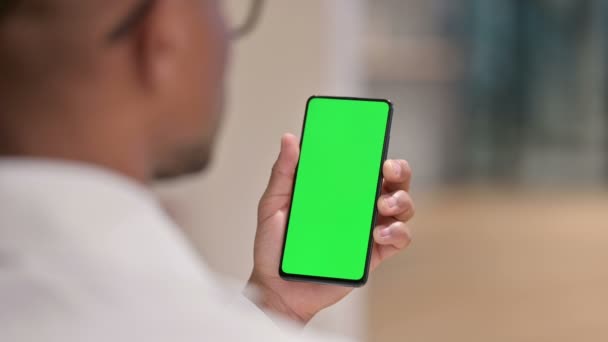 Зворотний вид чоловічого африканського лікаря з використанням смартфона з Chroma Screen — стокове відео