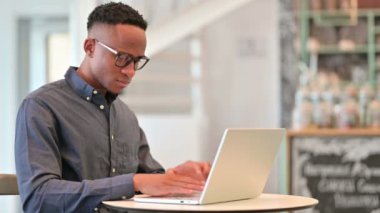 Laptop 'u olan yorgun Afrikalı Kafede Boyun Ağrısı Var 