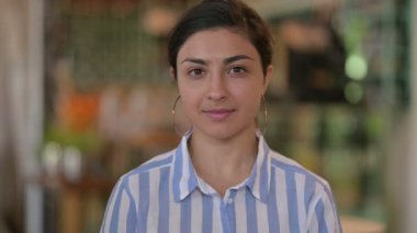 Kameraya bakan gülümseyen genç Hintli kadının portresi 