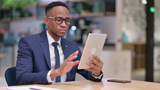 Un om de afaceri african sărbătorește succesul pe tabletă în birou — Videoclip de stoc