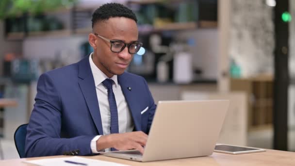 Uomo d'affari africano con il computer portatile che fa Pollici in ufficio — Video Stock