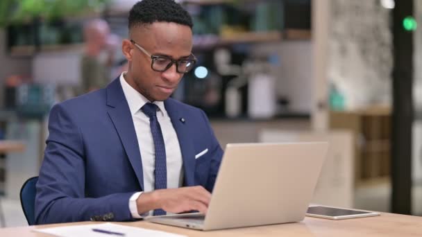 Junger afrikanischer Geschäftsmann mit Laptop zeigt auf die Kamera — Stockvideo