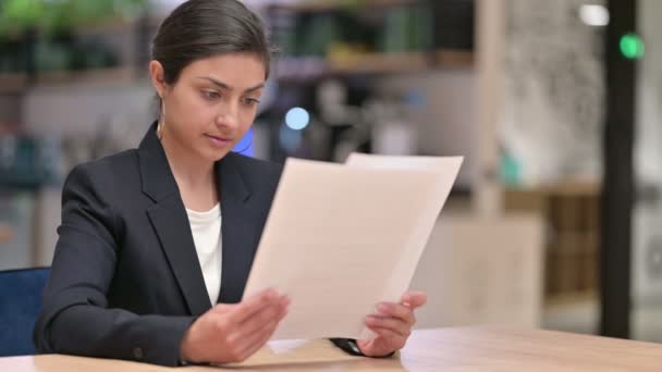 Jeune femme d'affaires indienne lisant des documents au bureau — Video