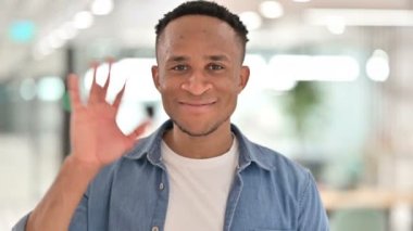 Kameraya el sallayan neşeli Afrikalı adamın portresi. 