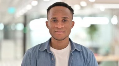 Kameraya gülümseyen neşeli bir Afrikalı adamın portresi