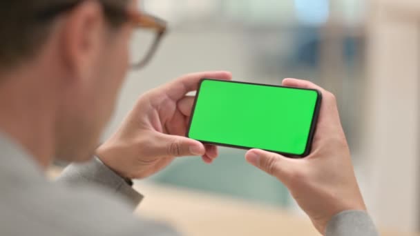 Achteraanzicht van de middelbare leeftijd Man Kijkend naar Smartphone met Chroma Screen — Stockvideo