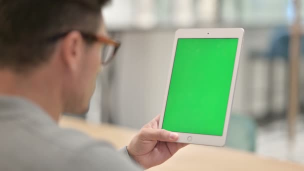 Achteraanzicht van de middelbare leeftijd Man op zoek naar tablet met chroma scherm — Stockvideo