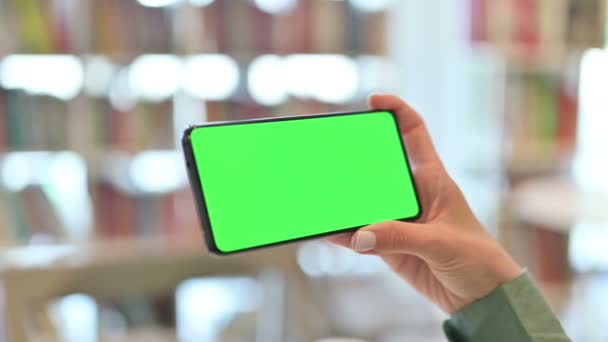 Vista posteriore della giovane donna che guarda Smartphone con schermo cromato — Video Stock