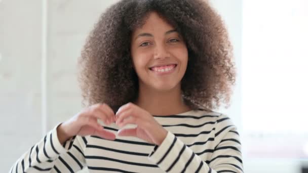 Retrato de mujer africana mostrando el signo del corazón con la mano — Vídeos de Stock