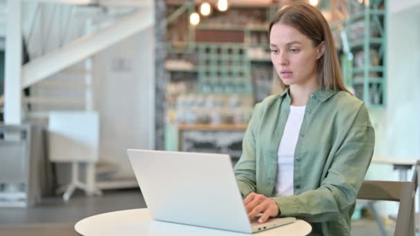 Gyönyörű fiatal nő záró laptop és megy el — Stock videók