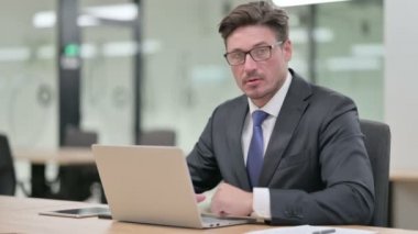 Ofisinde dizüstü bilgisayarı olan Ciddi Orta Çağ İşadamından Başparmak İndirme 