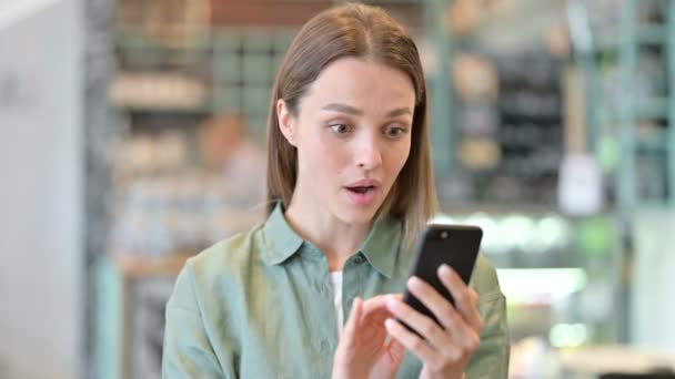 Retrato da mulher excitada comemorando o sucesso no smartphone — Vídeo de Stock