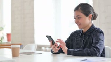 Akıllı telefon kullanan Ciddi Genç Hintli Kadın 