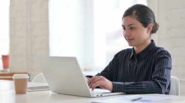 Dizüstü bilgisayarlı genç Hintli Kadın Kameraya Bakıyor 