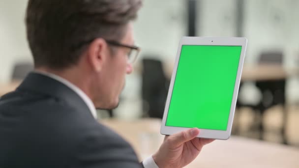 Vedere din spate a omului de afaceri folosind tableta cu ecran de crom — Videoclip de stoc