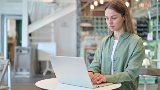 Jovem mulher focada trabalhando no laptop no café — Vídeo de Stock