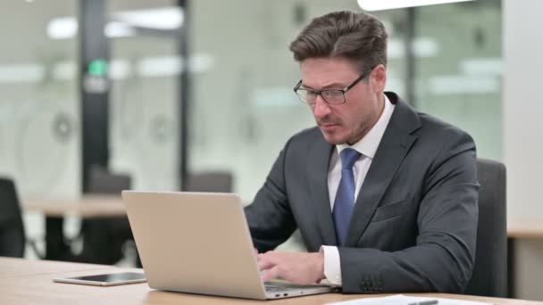 Müder Geschäftsmann mittleren Alters mit Laptop hat Nackenschmerzen im Büro — Stockvideo