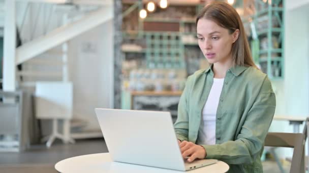 Aufgeregte Frau feiert Erfolg auf Laptop im Café — Stockvideo