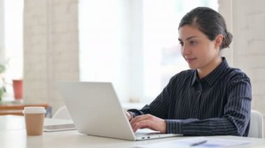 Dizüstü bilgisayarlı neşeli Hintli kadın Kameraya gülümsüyor 