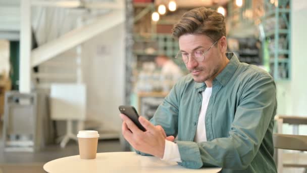 Homem de meia-idade atraente usando Smartphone no Café — Vídeo de Stock