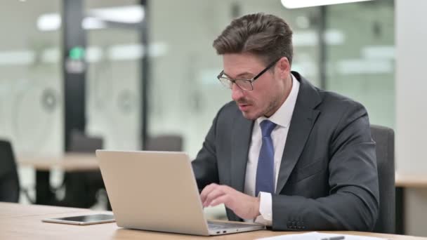 Aufgeregter Geschäftsmann mittleren Alters feiert Erfolg auf Laptop im Büro — Stockvideo