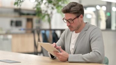 Tablet kullanan dalgın orta yaşlı adam 