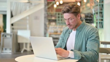 Orta Yaşlı Adam Bilgisayarı Kapatıyor ve Kafede Yürüyüp Gidiyor