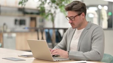 Dizüstü bilgisayarlı neşeli orta yaşlı adam Kameraya gülümsüyor 