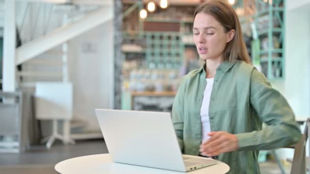 Stressad kvinna med bärbar dator har ryggvärk i Café — Stockvideo