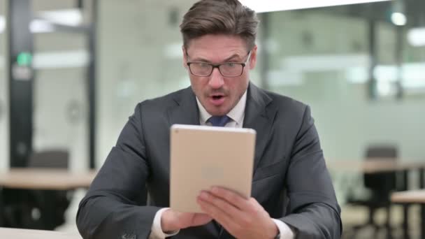 Retrato del hombre de negocios de mediana edad celebrando el éxito en la tableta — Vídeos de Stock