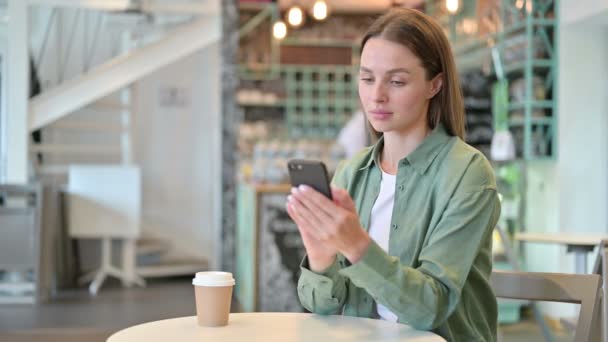 Jovem mulher séria usando Smartphone no Café — Vídeo de Stock