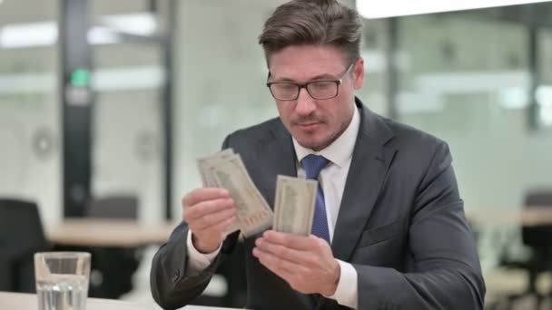 Portret van tevreden zakenman van middelbare leeftijd die dollars telt — Stockvideo