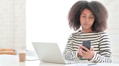 Akıllı telefon kullanan dizüstü bilgisayarı olan kadın