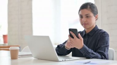 Akıllı telefon kullanan dizüstü bilgisayarlı Hintli Kadın