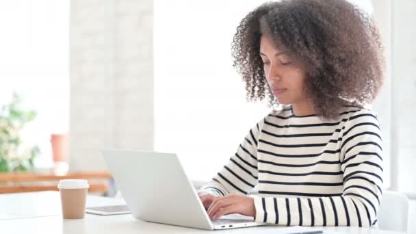 Afrikaanse vrouw met laptop op zoek naar camera — Stockvideo