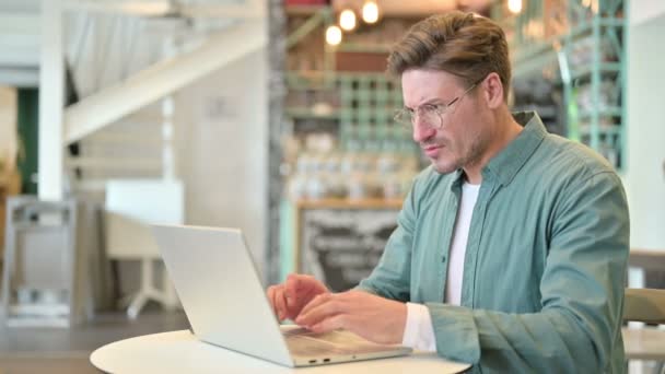 Ztráta, středověký muž reagující na selhání na notebooku v kavárně — Stock video